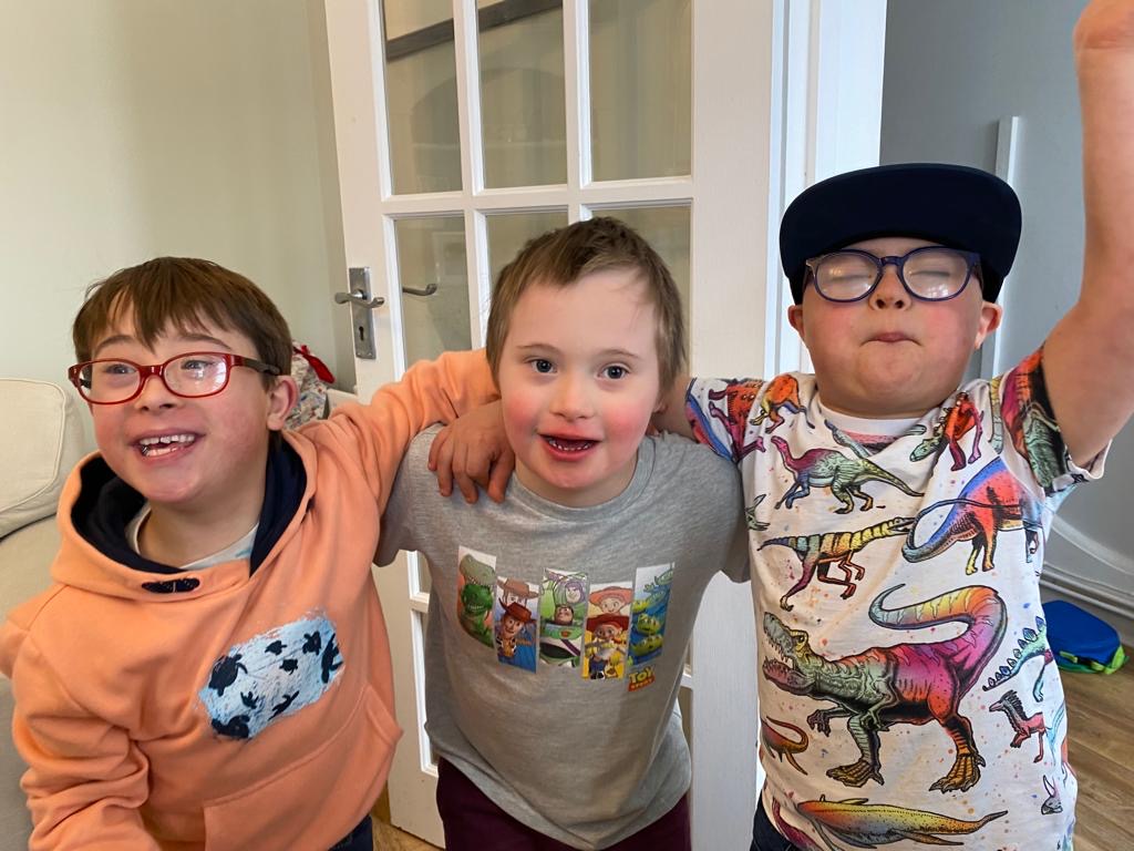 Three Youngsters arm in arm smiling at the camera